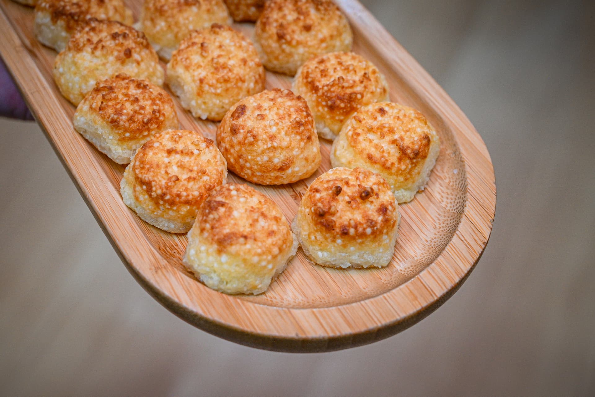 Tábua de pães de queijo dourados servidos em festa infantil na By Ange