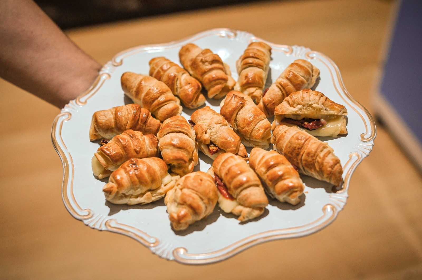 Prato com mini croissants folhados recheados servidos na By Ange