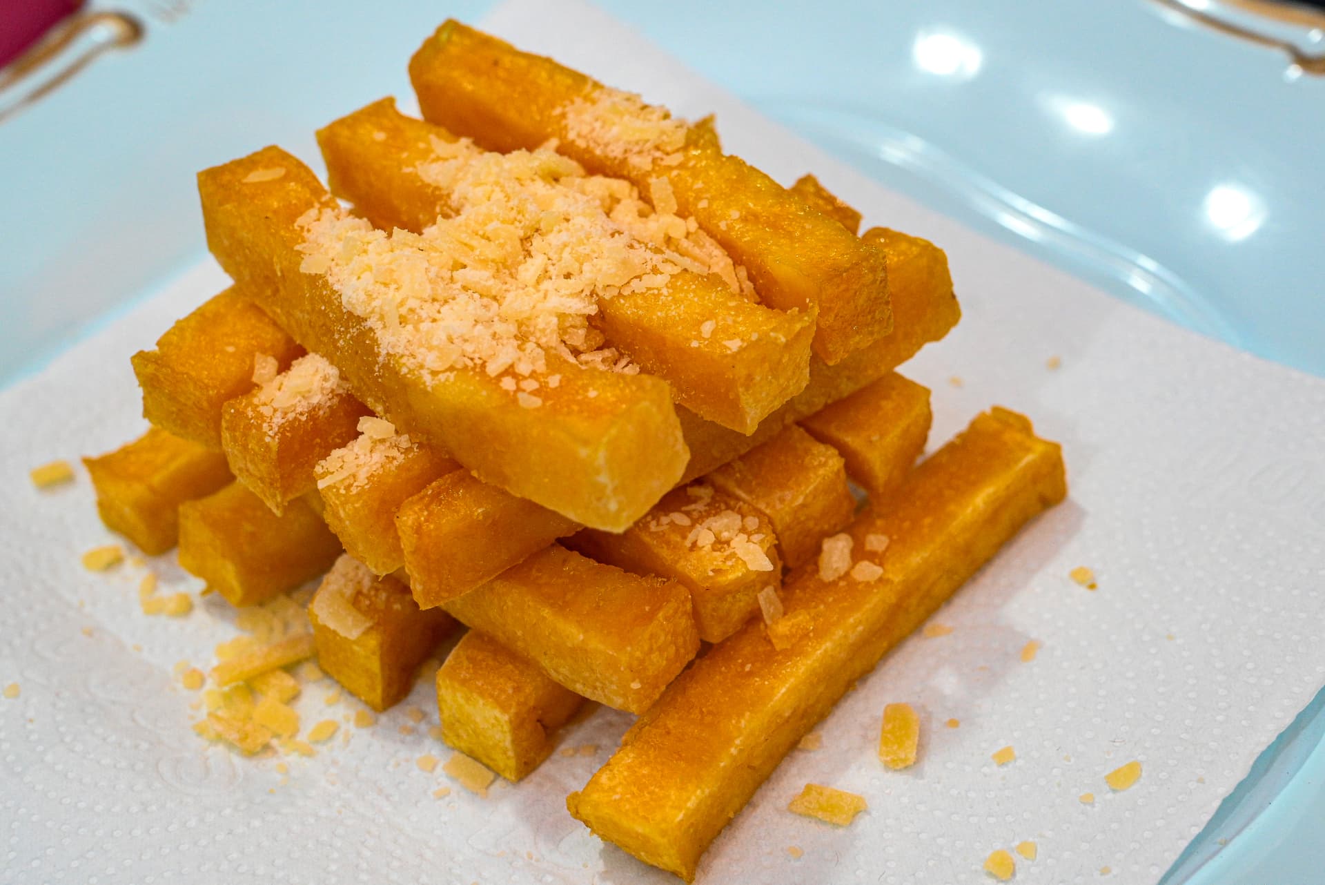 Porção de polenta frita crocante com parmesão ralado na By Ange